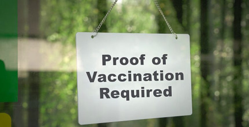 Signboard, Proof of Vaccination Required hanging on the door front of a shop. No vaccine, no entry concept.